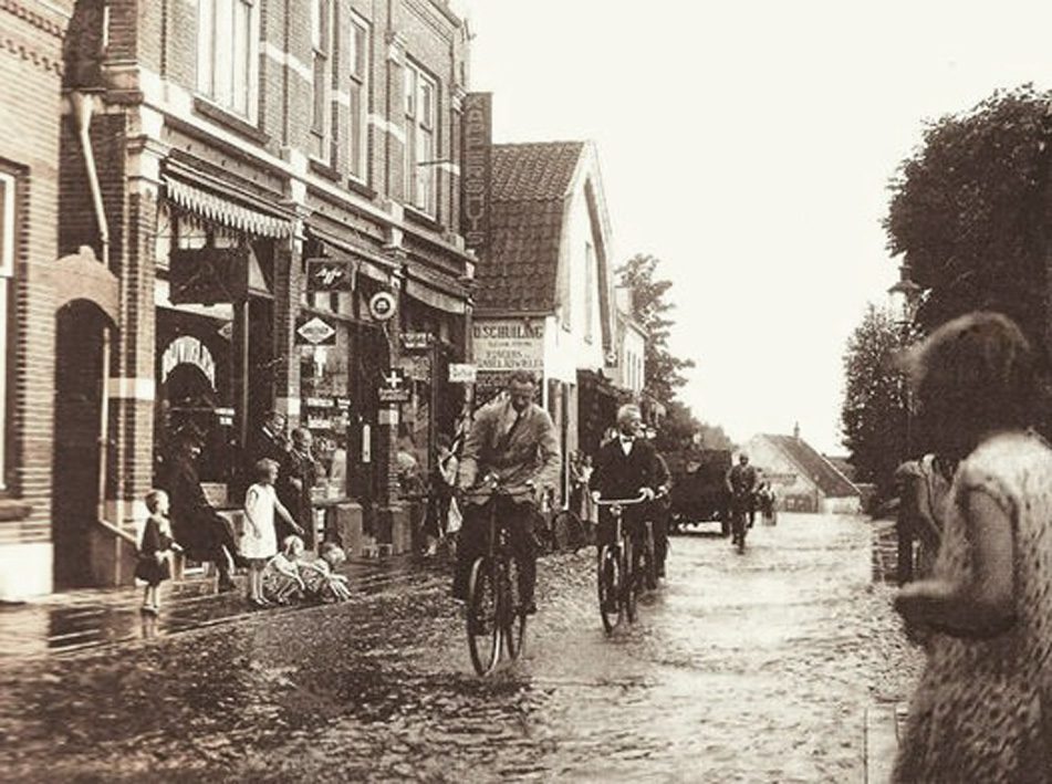 In een andermaal overstroomde Weverstraat zien we in het enigszins uitstekende pand de rijwielhersteller D. Schuiling, daarvoor de kappers K.en W. J. Wils. De eerste afficheerde zich als coiffeur de tweede als barbier. In het pand daarvoor de smid H. Heidelberg en op nummer 74 de electricien Chr. Tesink.